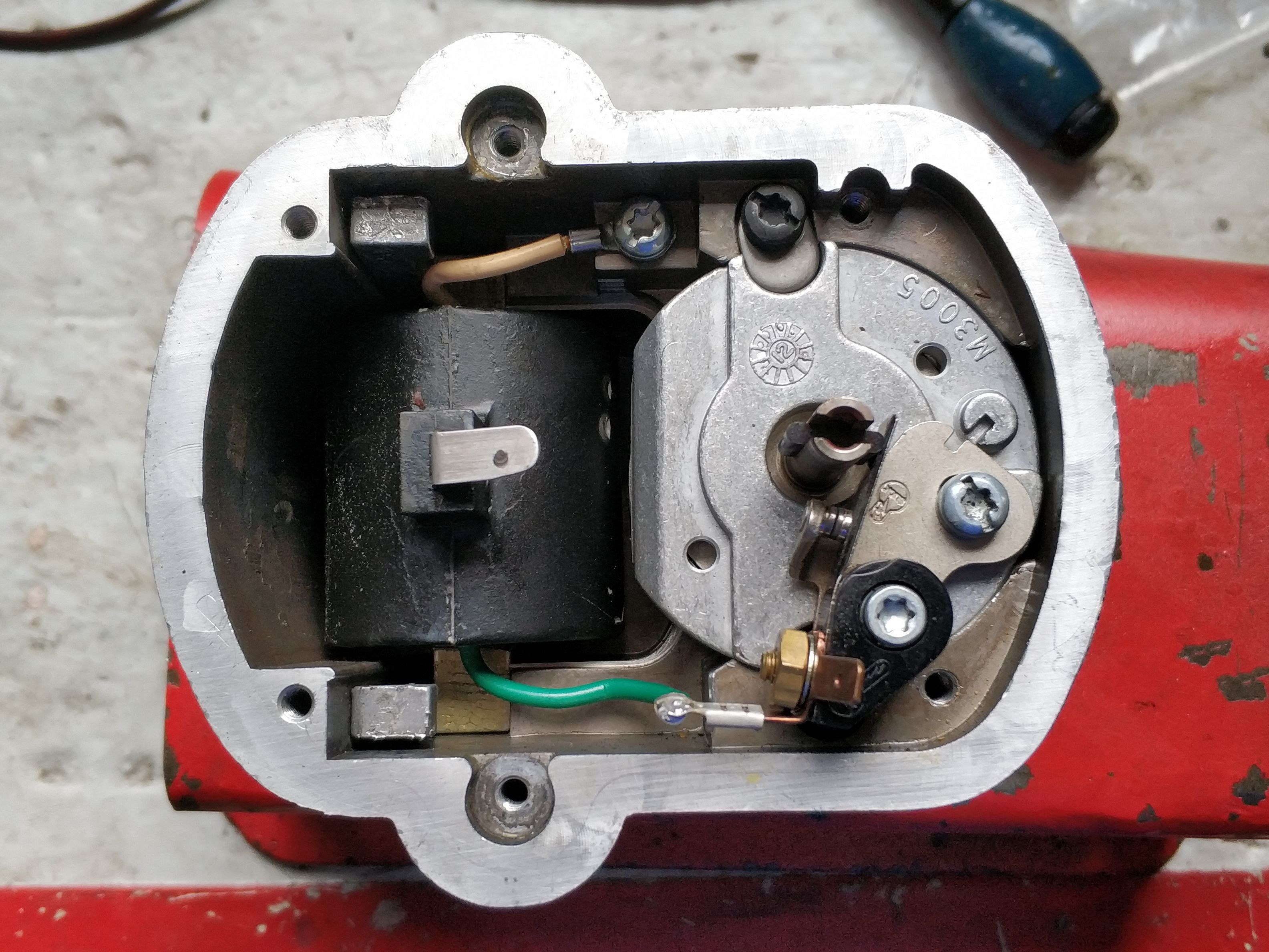 The disassembled magneto; the breaker is on the right and the coil is on the left.